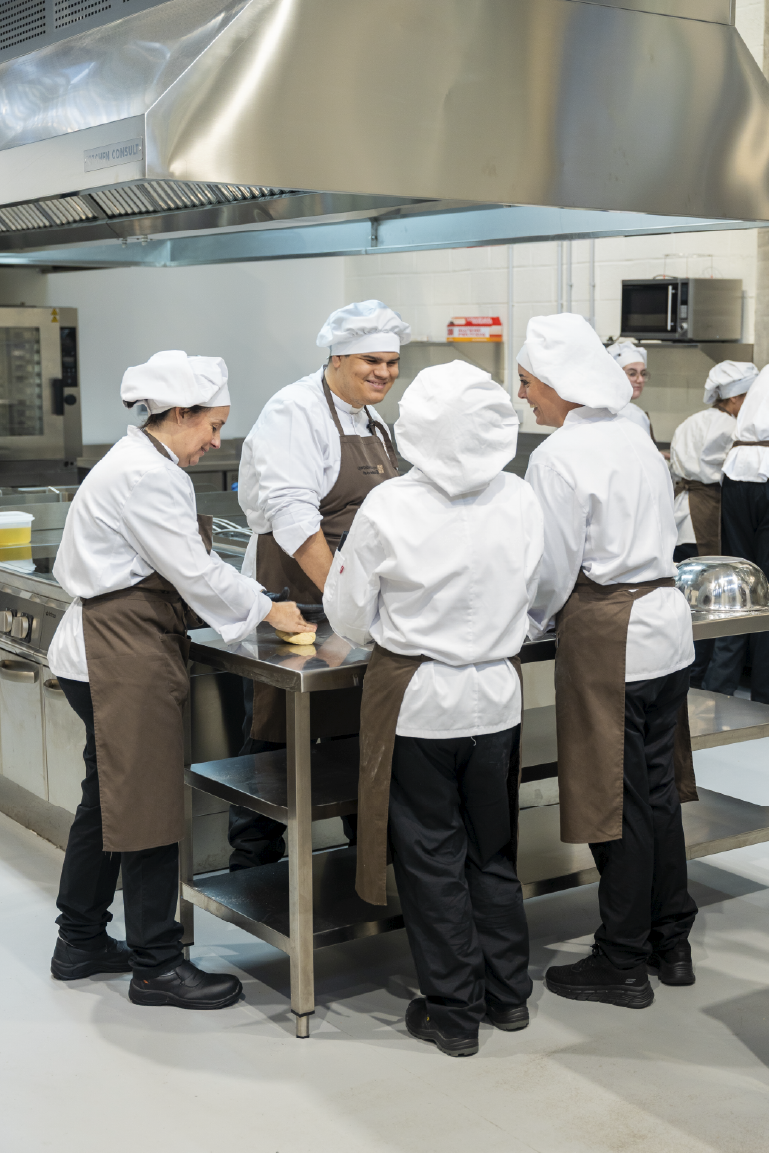 Alumnos cocinando y dando clase en la Escuela superior de hostelería de españa ESHE pasandolo muy bien y aprendiendo mucho de forma práctica en su grado superior de hosyeleria, gastronomia y cocina.